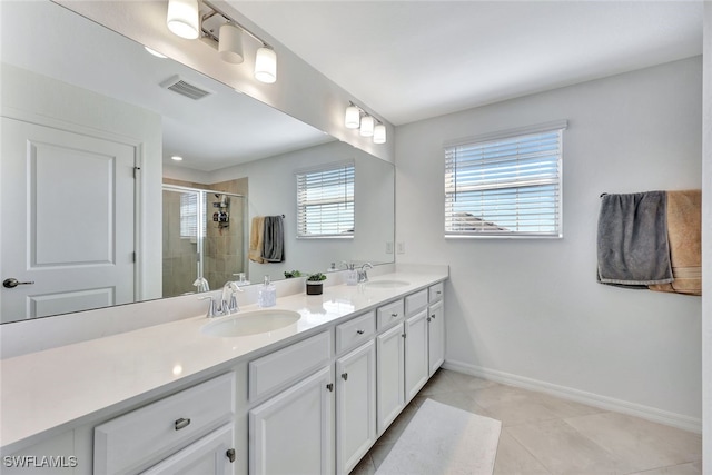 bathroom featuring tile patterned flooring, vanity, and walk in shower