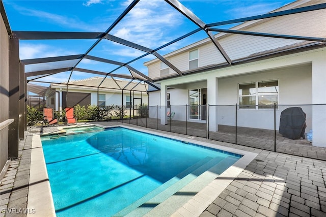 view of swimming pool with a patio and glass enclosure