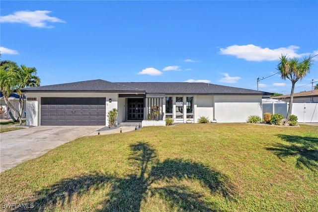 ranch-style house featuring a garage and a front lawn