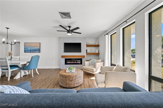 living room featuring hardwood / wood-style flooring and ceiling fan with notable chandelier