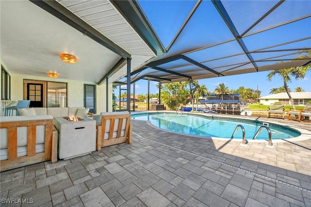 view of swimming pool featuring an outdoor fire pit, a lanai, and a patio area