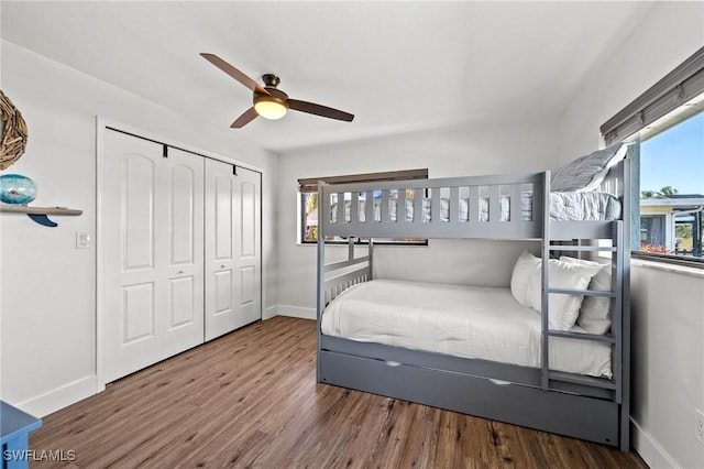 bedroom with dark hardwood / wood-style floors, ceiling fan, and a closet