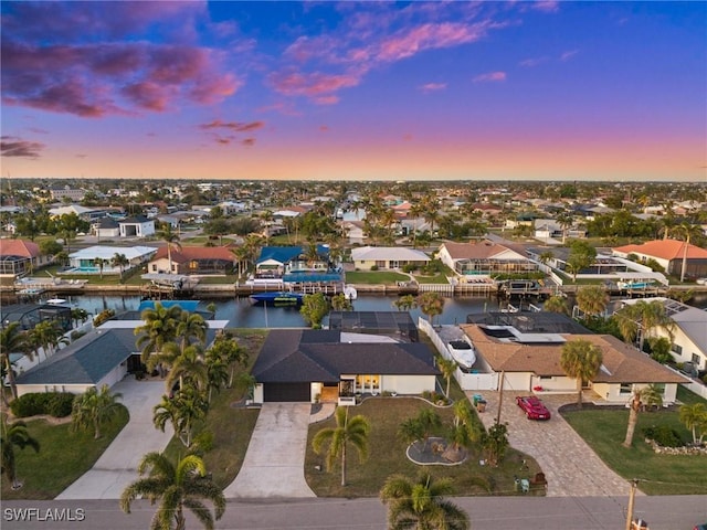 aerial view at dusk featuring a water view