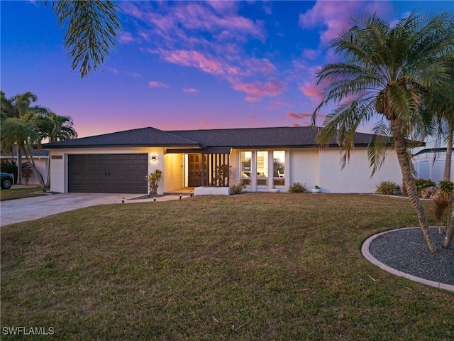 single story home with a garage and a yard