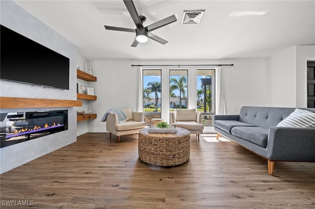 living room featuring ceiling fan and hardwood / wood-style floors