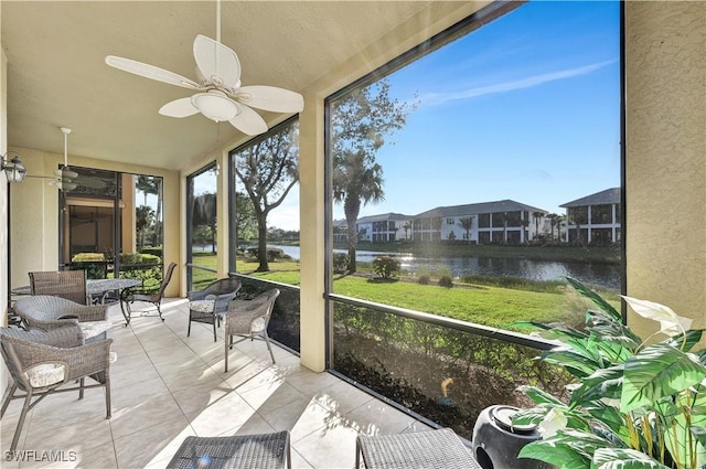 sunroom / solarium with a water view and ceiling fan