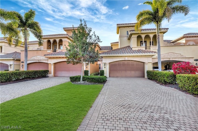 mediterranean / spanish-style house with a balcony, a garage, and a front lawn