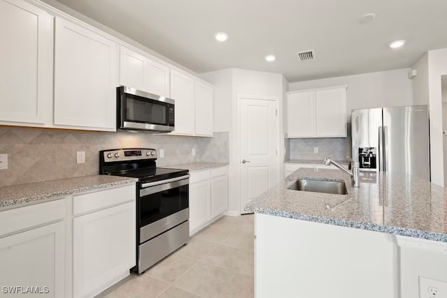 kitchen with stainless steel appliances, white cabinetry, and sink