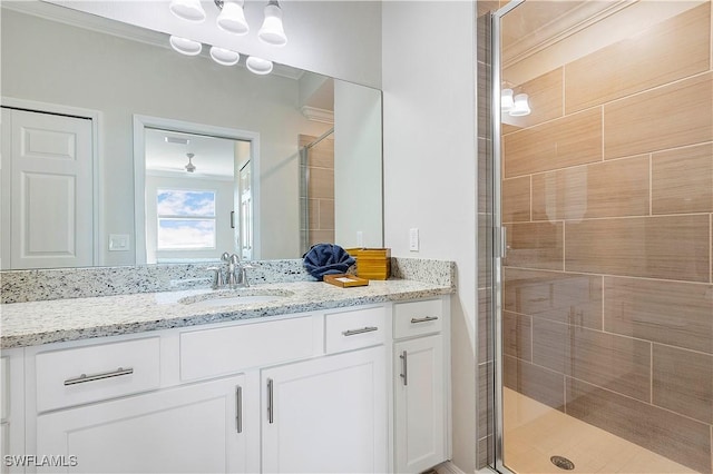 bathroom featuring a shower with door and vanity