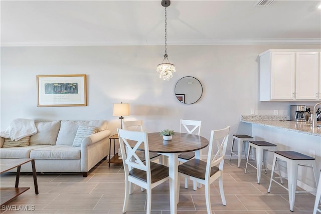 dining space featuring crown molding and an inviting chandelier