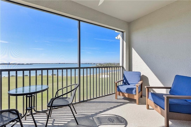 sunroom featuring a water view