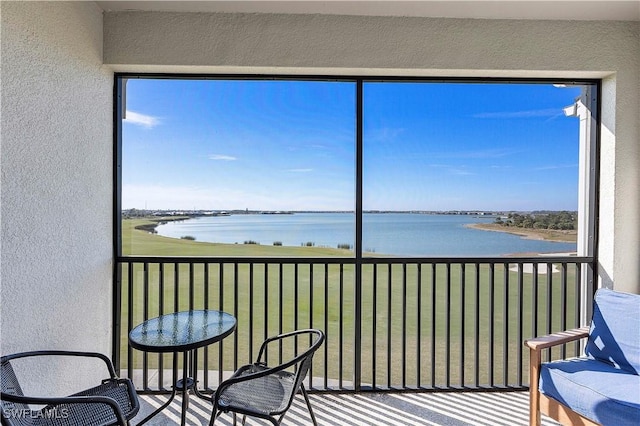 sunroom / solarium featuring a water view