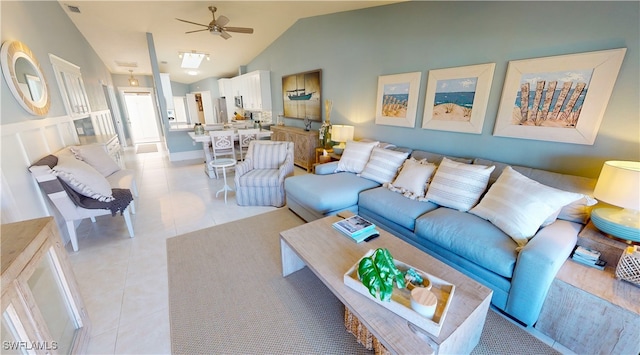 living room featuring lofted ceiling, light tile patterned floors, and ceiling fan