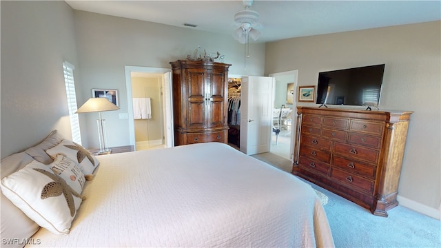 bedroom with ceiling fan, light carpet, a spacious closet, vaulted ceiling, and a closet