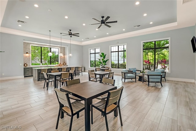 dining room with ceiling fan and a raised ceiling