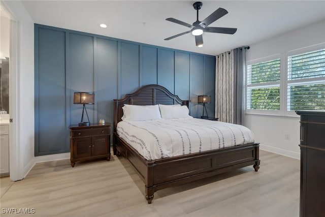 bedroom featuring ensuite bathroom, light wood-type flooring, and ceiling fan