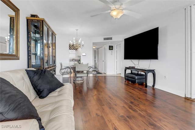 living room featuring visible vents, baseboards, wood finished floors, and ceiling fan with notable chandelier