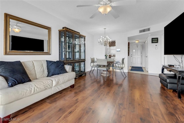 living area featuring visible vents, baseboards, wood finished floors, and ceiling fan with notable chandelier