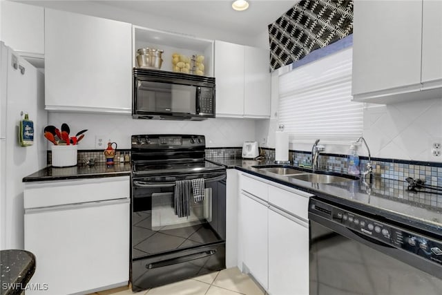 kitchen featuring black appliances, a sink, dark stone countertops, white cabinets, and decorative backsplash