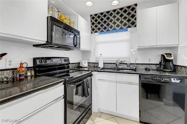 kitchen featuring dark stone counters, a sink, decorative backsplash, black appliances, and white cabinets