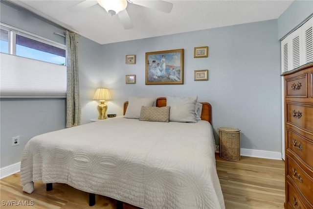 bedroom featuring wood finished floors, baseboards, and ceiling fan