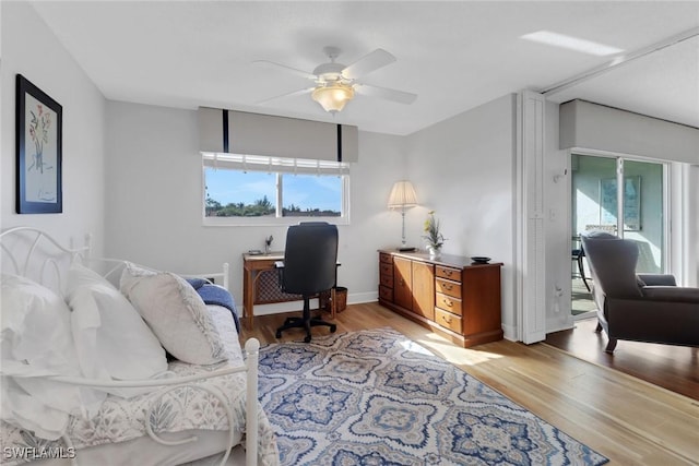 office featuring plenty of natural light, a ceiling fan, baseboards, and light wood finished floors