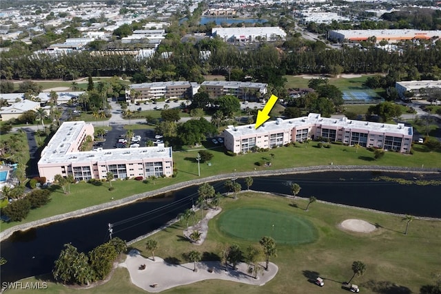 drone / aerial view featuring golf course view and a water view