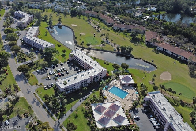 birds eye view of property with golf course view and a water view