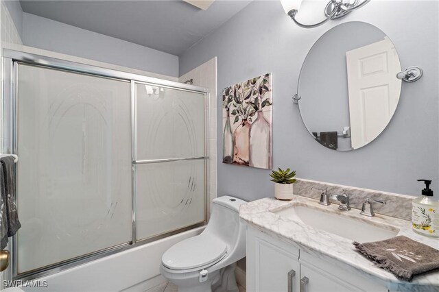 full bathroom featuring toilet, vanity, and shower / bath combination with glass door