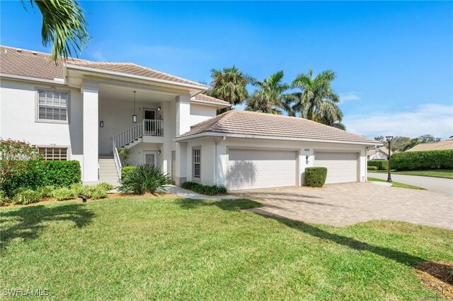 mediterranean / spanish-style home featuring a garage and a front yard