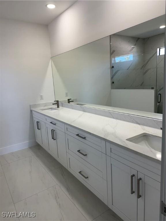 bathroom featuring a shower with door and vanity