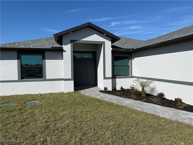 property entrance with a lawn