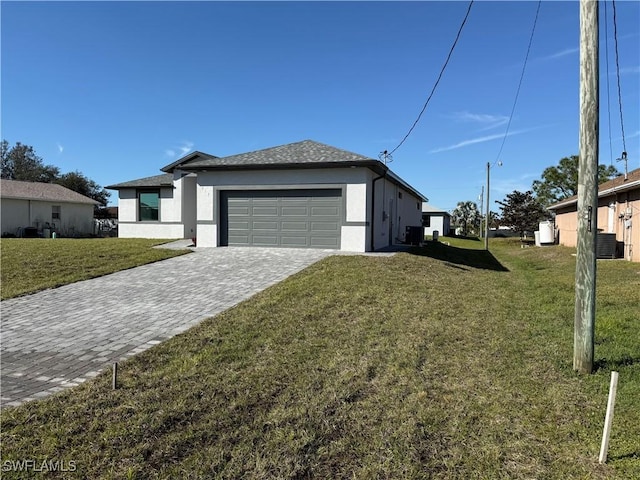 view of side of property featuring a garage, a yard, and central air condition unit