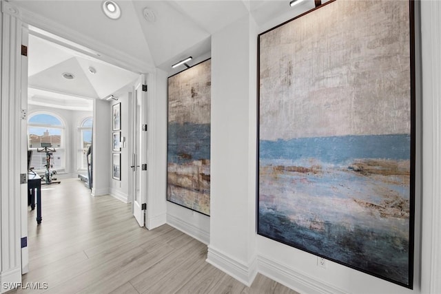 hallway with lofted ceiling and light hardwood / wood-style flooring