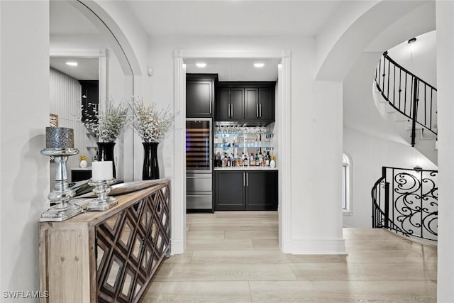 bar featuring wood counters, light hardwood / wood-style floors, and beverage cooler