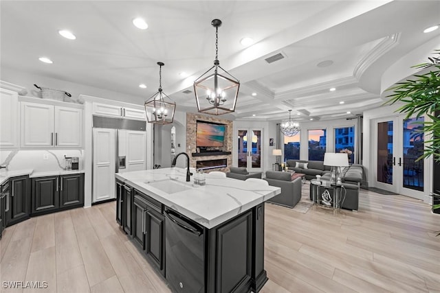 kitchen with white cabinetry, decorative light fixtures, paneled built in fridge, and sink