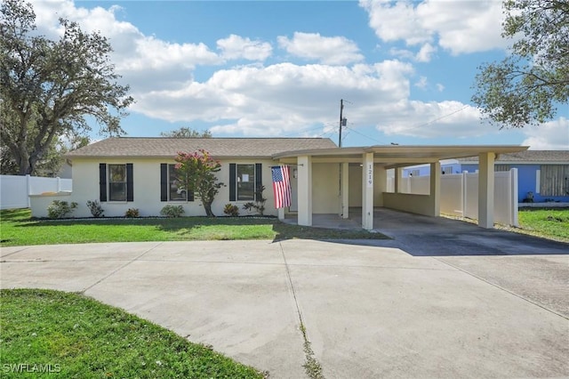 ranch-style house featuring a carport and a front lawn