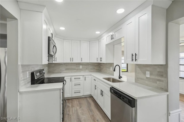 kitchen featuring white cabinetry, appliances with stainless steel finishes, sink, and backsplash