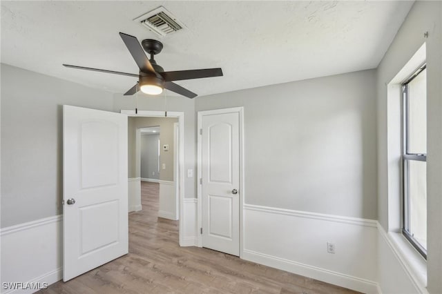 unfurnished bedroom featuring multiple windows, light hardwood / wood-style flooring, and ceiling fan