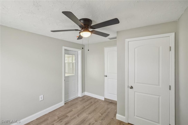 unfurnished bedroom with ceiling fan, light hardwood / wood-style flooring, and a textured ceiling