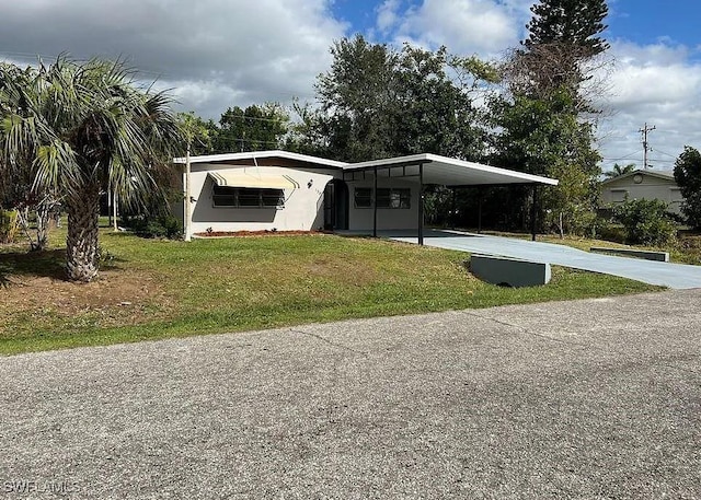 manufactured / mobile home featuring a carport and a front yard