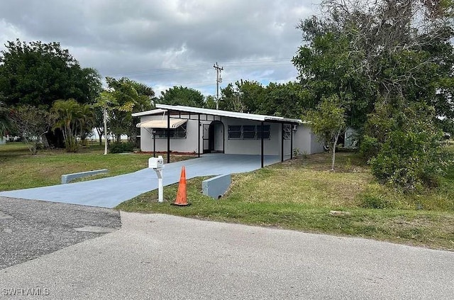 view of front of house with a carport and a front yard