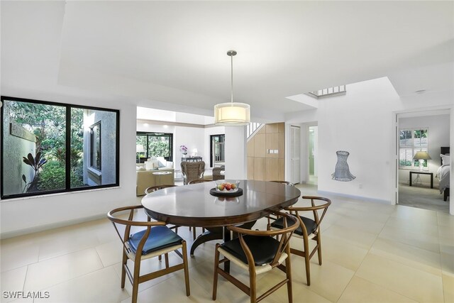 dining space with light tile patterned flooring and plenty of natural light