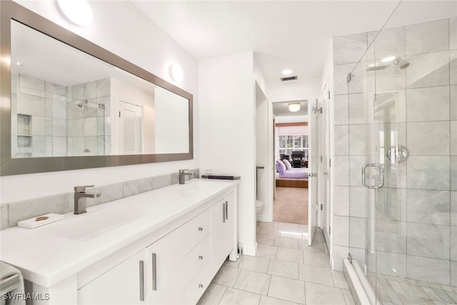 bathroom featuring tile patterned flooring, vanity, an enclosed shower, and toilet