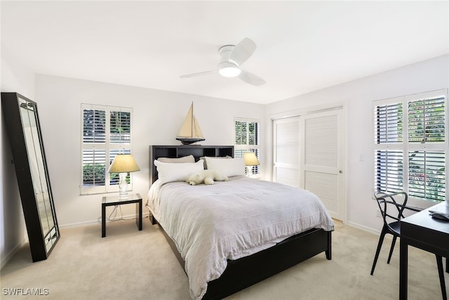 bedroom with ceiling fan, baseboards, a closet, and light colored carpet