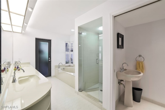 full bath with dual sinks, tile patterned floors, a garden tub, and a shower stall