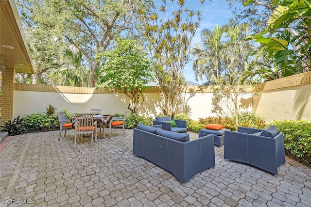 view of patio featuring a fenced backyard, outdoor lounge area, and outdoor dining space