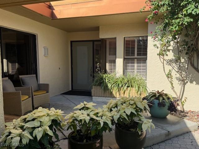 entrance to property featuring a patio area and stucco siding