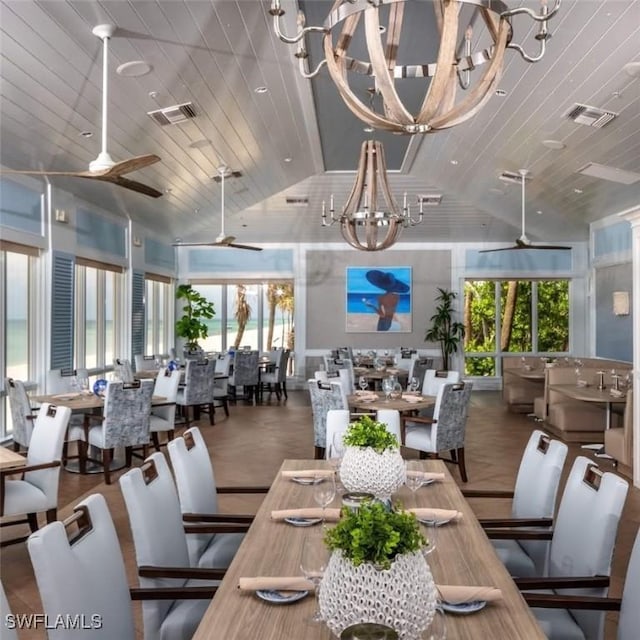 dining room featuring a healthy amount of sunlight, ceiling fan with notable chandelier, and high vaulted ceiling