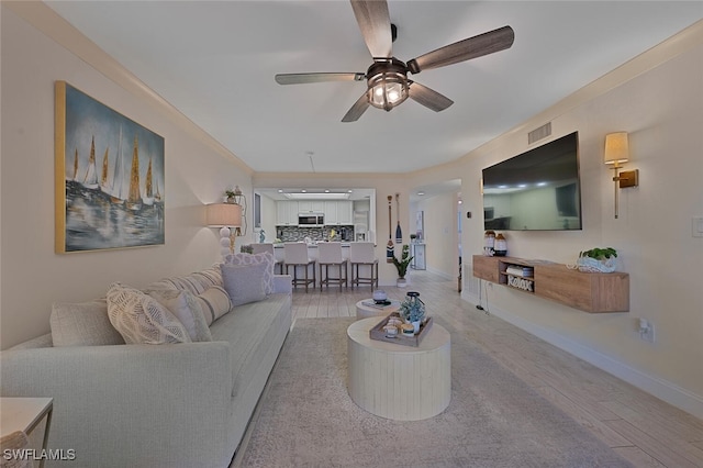 living room featuring ceiling fan and light hardwood / wood-style flooring